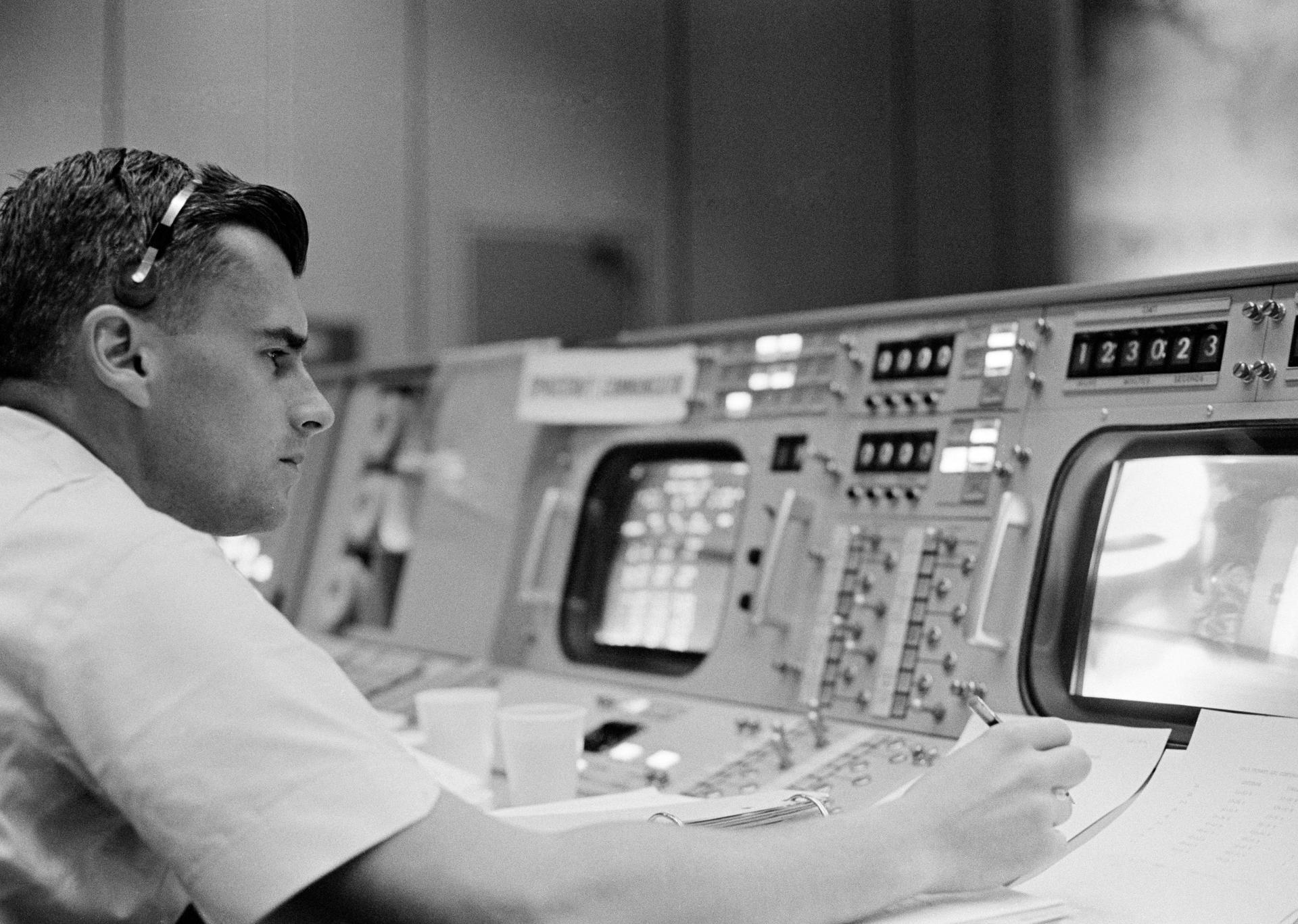 Roger Chaffee sits at a console in Mission Control