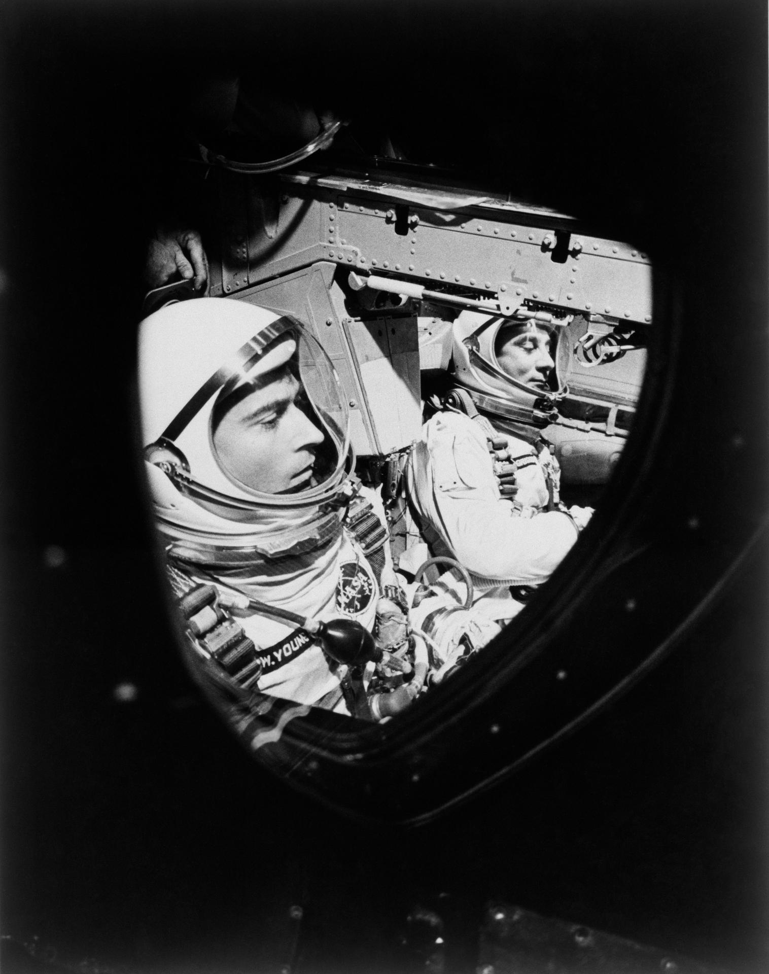 John Young and Gus Grissom seen through the window of the Gemini-Titan 3 spacecraft