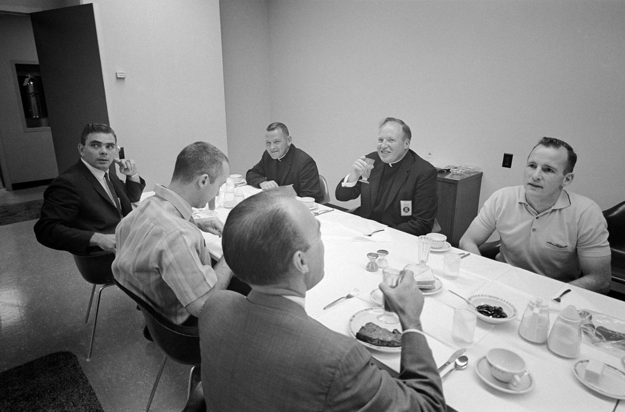 S65-19600 (3 June 1965) --- The prime crew for the Gemini-Titan 4 mission have an early morning breakfast prior to their historic flight which was launched at 10:16 a.m. (EST) on June 3, 1965. Shown here seated around the table (clockwise starting front center) are Dr. D. Owens Coons, chief, MSC Center Medical Office; astronaut James A. McDivitt, GT-4 command pilot; Dr. Eugene F. Tubbs, Kennedy Space Center; Rt. Rev. James Heiliky, McDivitt's priest at Cocoa Beach, Florida; Msgr. Irvine J. Nugent and astronaut Edward H. White II, GT-4 pilot. The group had a breakfast of tomato juice, broiled sirloin steak, poached eggs, toast, strawberry gelatin and coffee.