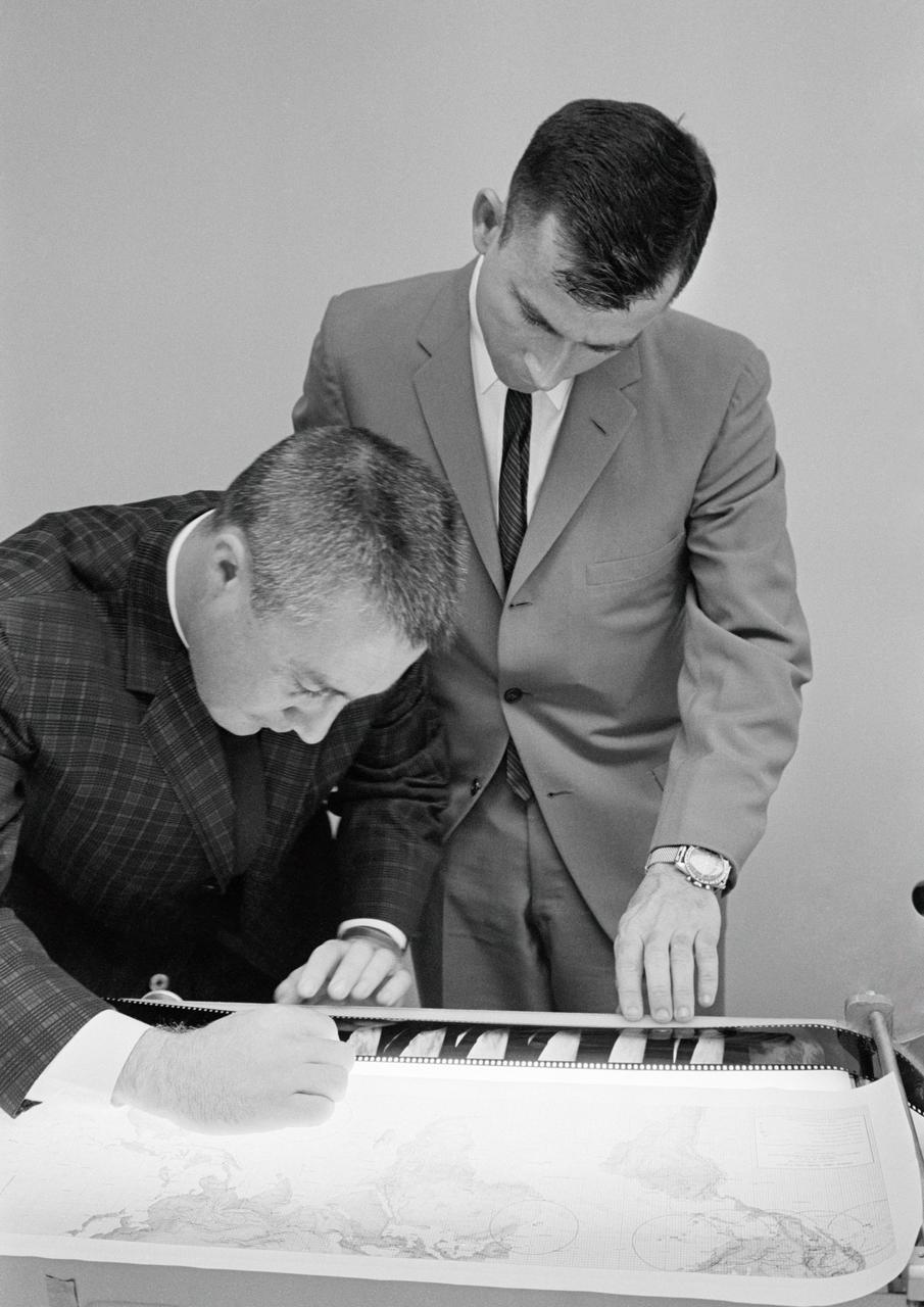 S65-20624 (25 March 1965) --- Gemini-Titan 3 astronauts Virgil I. Grissom (left) and John W. Young examine some of the negatives of photographs taken on their three-orbit flight on March 23, 1965.