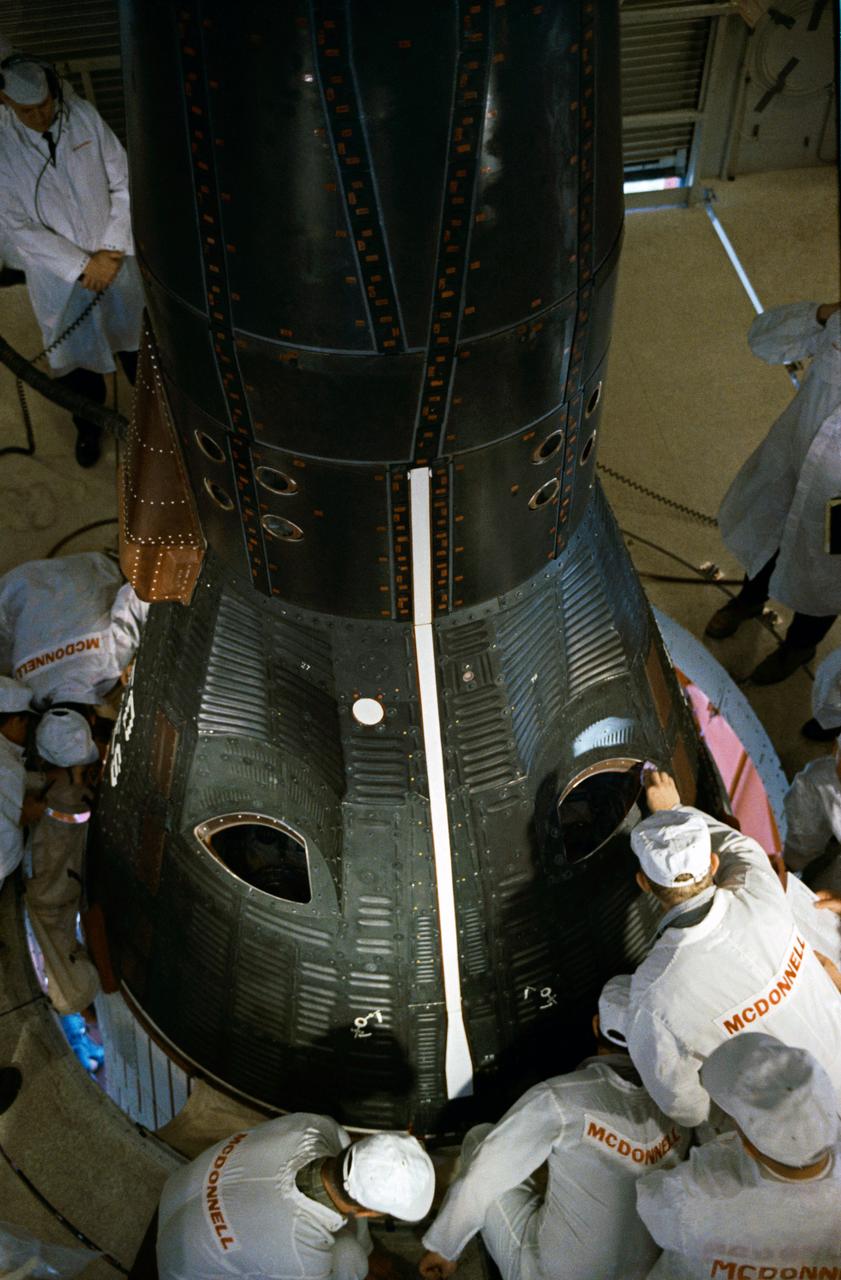 S65-21090 (23 March 1965) --- Astronauts Virgil I. Grissom, command pilot; and John W. Young, pilot, wait inside their Gemini-3 spacecraft just after the hatches were closed prior to liftoff. McDonnell Aircraft Corp. technicians can be seen making final adjustments and inspection prior to leaving the white room atop the Titan launch vehicle at Pad 19, Cape Kennedy, Florida. The Gemini-Titan 3 spacecraft is being prepared for launch.