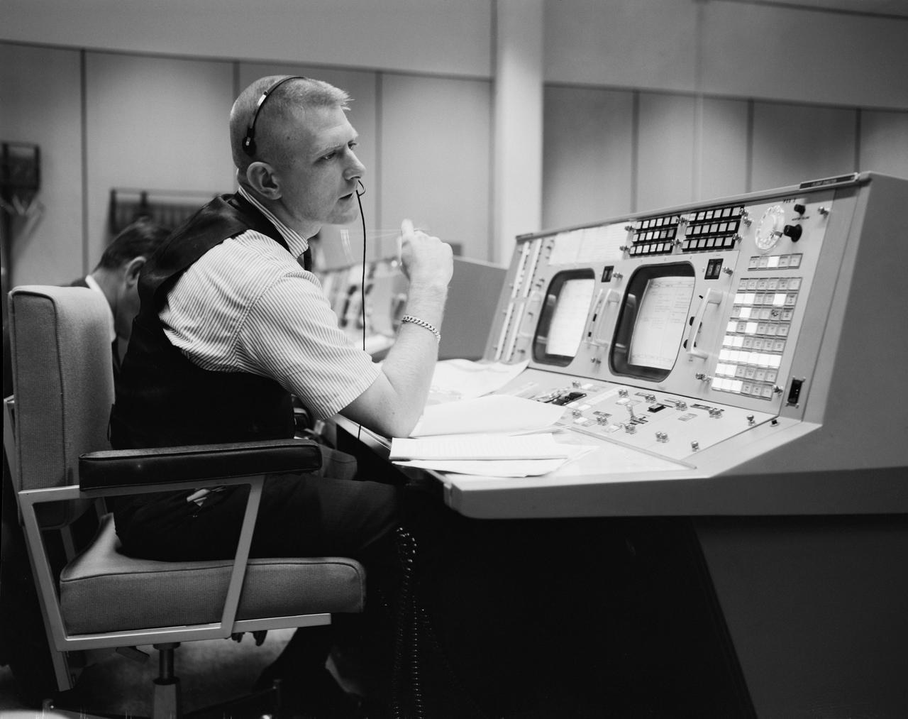S65-22203 (April 1965) --- Prior to the Gemini-Titan 4 mission, flight director Eugene F. Kranz is pictured during a simulation at the Flight Director console in Houston's Mission Control Center on the Manned Spacecraft Center site. GT-4 was the first mission to be at least partially controlled from the Houston site.  Photo credit: NASA