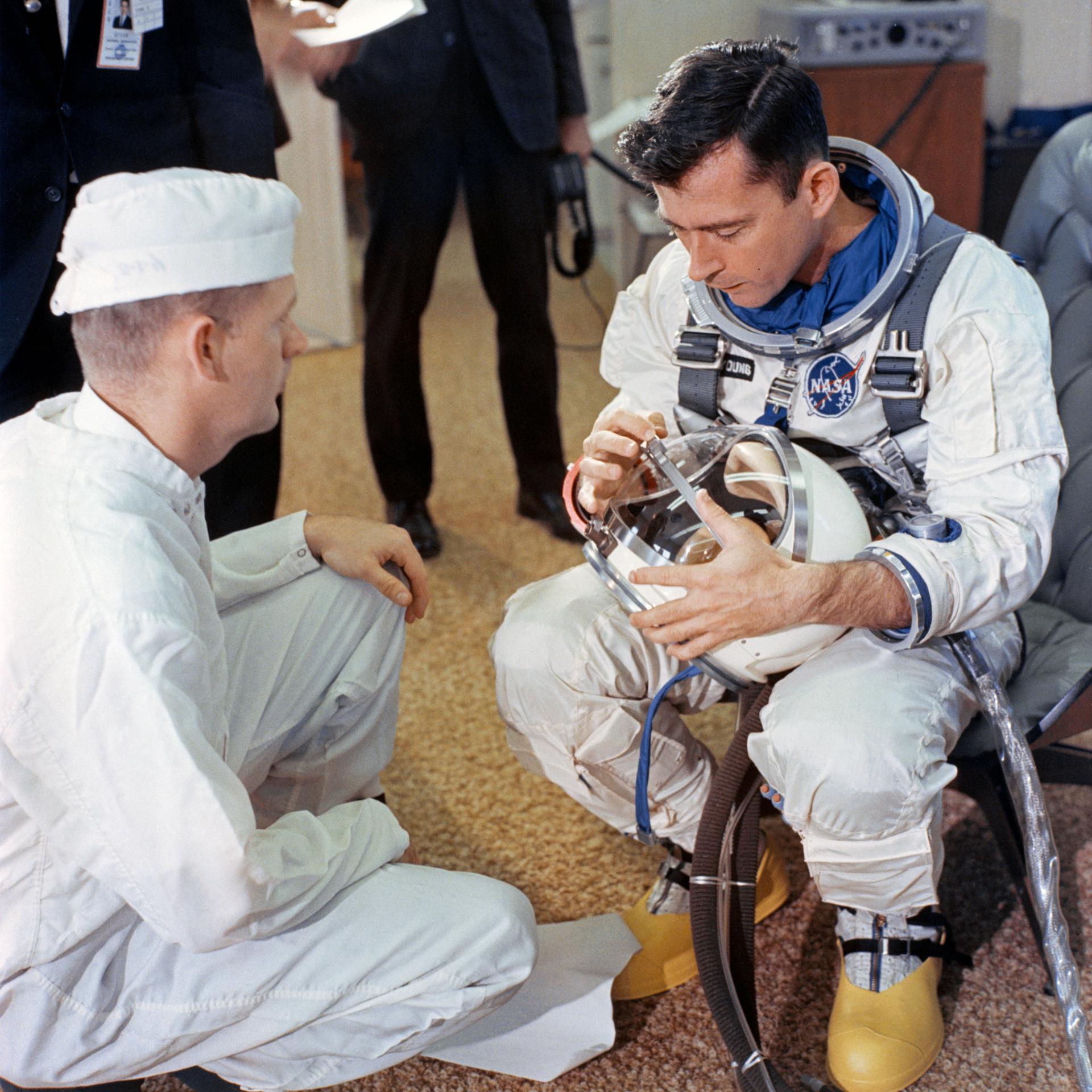 John Young looks at his helmet on the day of the Gemini III flight
