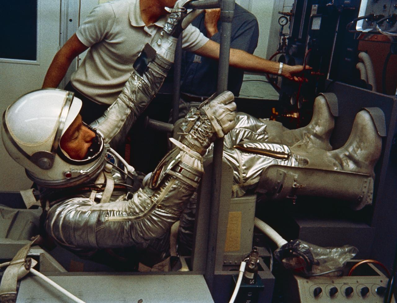 S65-24623 (May 1962) --- Astronaut M. Scott Carpenter, prime pilot for the Mercury-Atlas 7 (MA-7) flight, is seen in Hangar S crew quarters during a suiting exercise. Carpenter is seated in a mock-up of his pilot's seat while fully suited. Photo credit: NASA