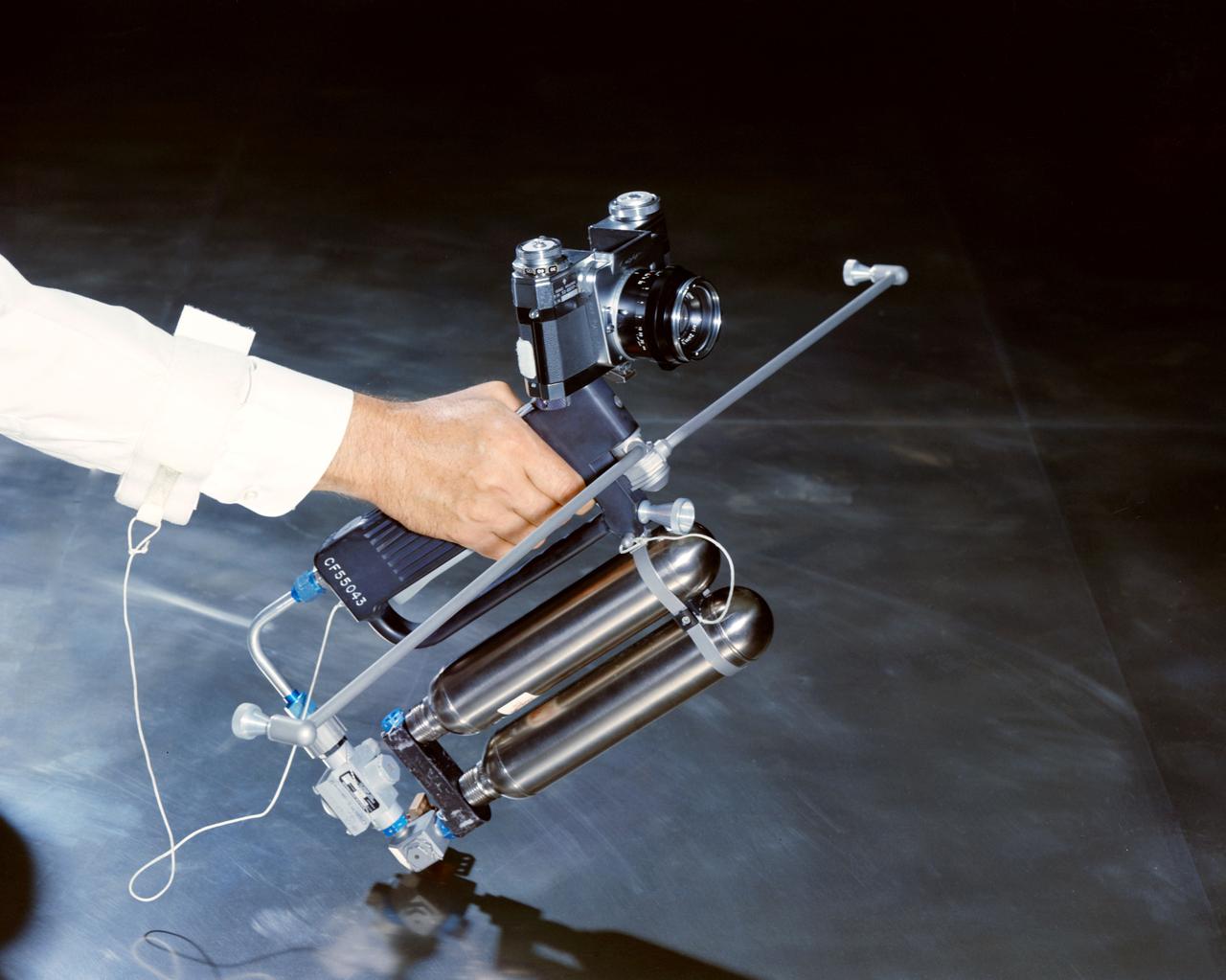 Hand-Held Self-Maneuvering Unit to be used during extravehicular activity (EVA) on Gemini 4 flight. It is an integral unit that contains its own high pressure metering valves and nozzles required to produce controlled thrust. A camera is mounted on the front of the unit.