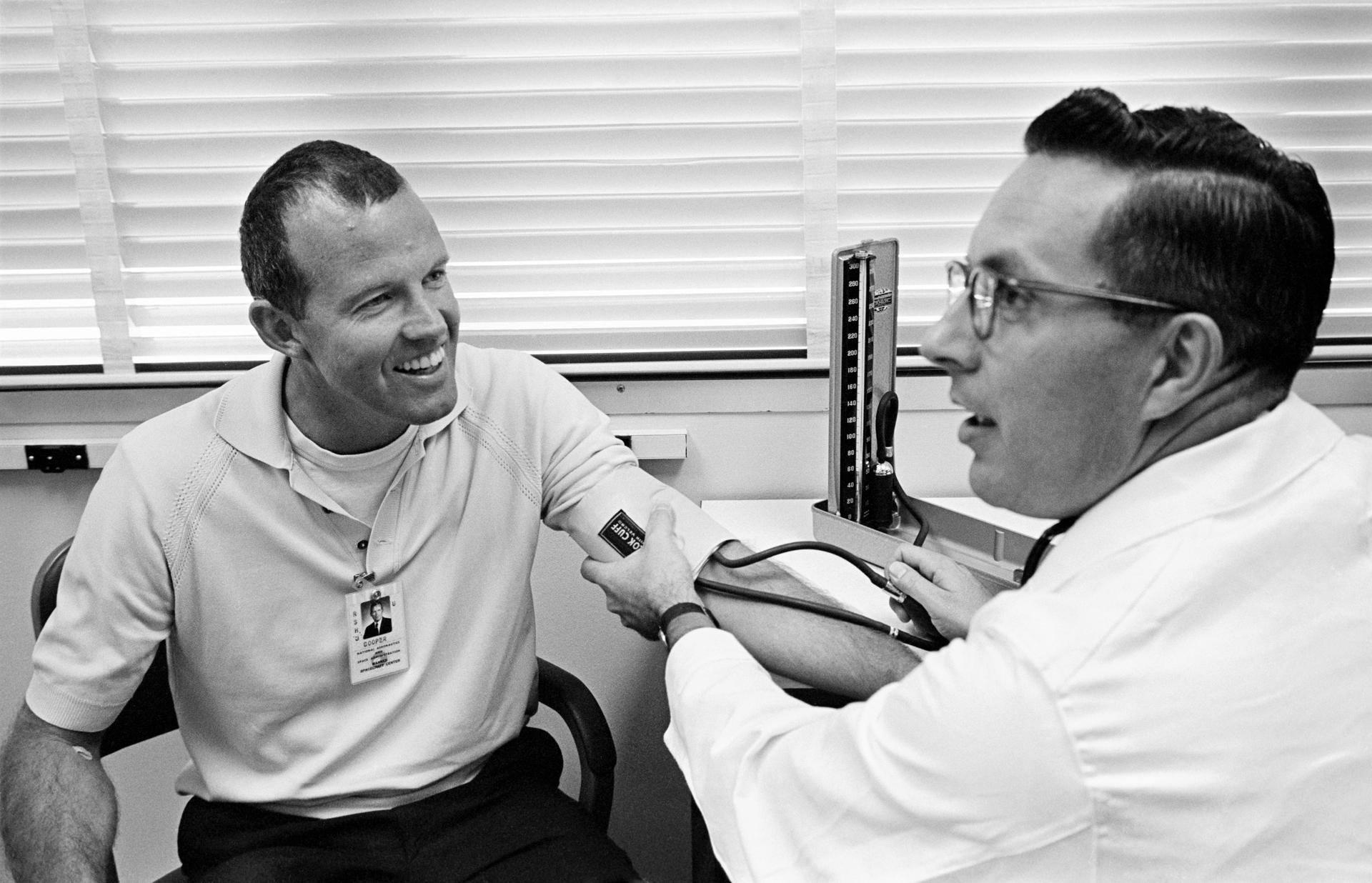 Gordon Cooper smiles as he has his blood pressure taken