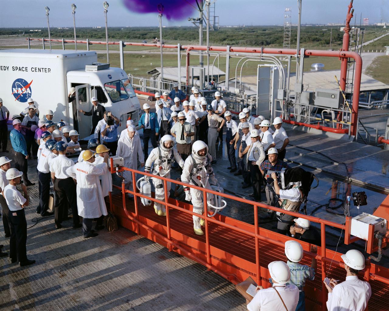 S65-28737 (21 Aug. 1965) --- Astronauts L. Gordon Cooper Jr. (foreground) and Charles Conrad Jr. walk up gantry ramp after arriving at Pad 19 during Gemini-5 countdown at Cape Kennedy, Florida.