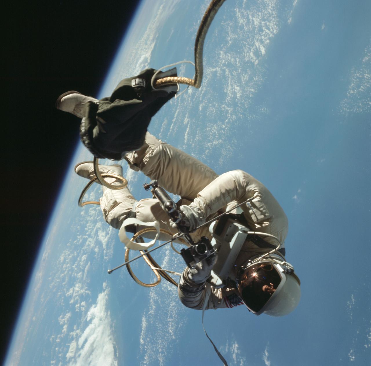 S65-30432 (3 June 1965) --- Astronaut Edward H. White II, pilot of the Gemini IV four-day Earth-orbital mission, floats in the zero gravity of space outside the Gemini IV spacecraft. White wears a specially designed spacesuit; and the visor of the helmet is gold plated to protect him against the unfiltered rays of the sun. He wears an emergency oxygen pack, also. He is secured to the spacecraft by a 25-feet umbilical line and a 23-feet tether line, both wrapped in gold tape to form one cord. In his right hand is a Hand-Held Self-Maneuvering Unit (HHSMU) with which he controls his movements in space.  Astronaut James A. McDivitt, command pilot of the mission, remained inside the spacecraft.    EDITOR'S NOTE: Astronaut White died in the Apollo/Saturn 204 fire at Cape Kennedy on Jan. 27, 1967.