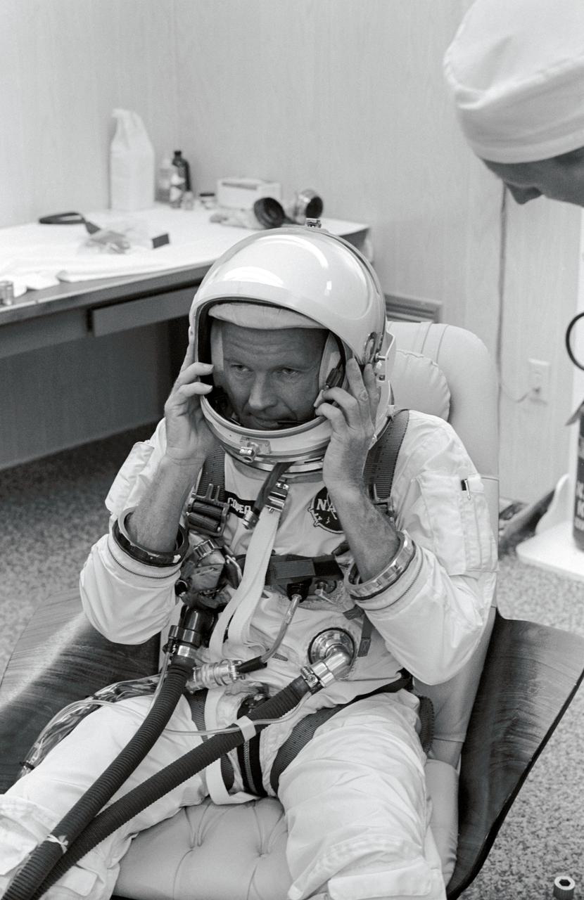 S65-41886 (22 July 1965) --- Astronaut L. Gordon Cooper Jr. makes adjustments to his helmet during suiting up exercise at Pad 16, Cape Kennedy, Florida. He is preparing for the Gemini-5 spaceflight. Photo credit: NASA
