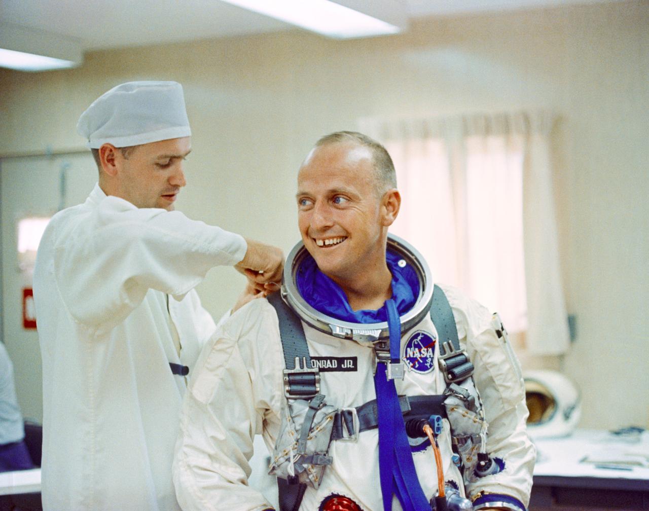 S65-41955 (12 July 1965) --- Astronaut Charles Conrad Jr. receives assistance with his pressure suit during suiting up and ingress test activity at Pad 16, Cape Kennedy, Florida in preparation for the Gemini-5 spaceflight.