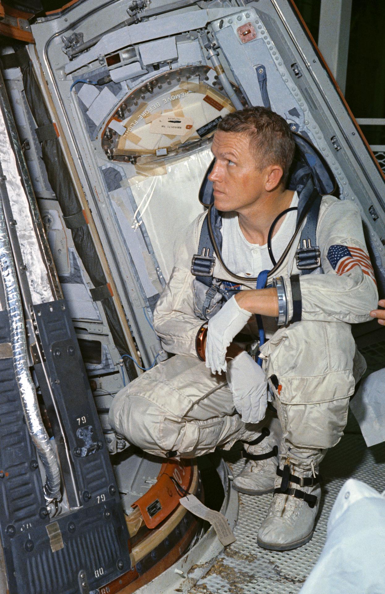 Astronaut Frank Borman looks over the Gemini-7 spacecraft during weight and balance tests.