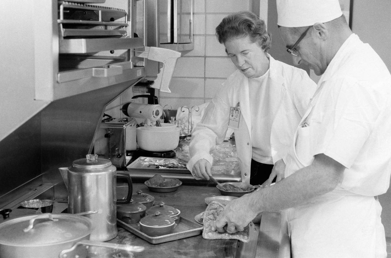 S65-56311 (2 Dec. 1965) --- Kennedy Space Center food specialists prepare an Earth-bound meal for Gemini-7 astronauts. Astronauts' diet is strictly controlled before and during spaceflights to avoid interfering with planned medical experiments. Photo credit: NASA