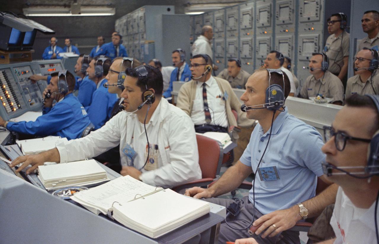 S65-59931 (4 Dec. 1965) --- Astronaut Alan Bean (right), spacecraft communicator for the Gemini-7 mission, joins other personnel (including H.K. "Fritz" Widick in dark jacket running launch operations) in the Blockhouse at Launch Complex 19 during the launch of the Gemini-7 spacecraft at 2:30 p.m. (EST), Dec. 4, 1965. Astronaut Frank Borman, command pilot, and James A. Lovell Jr., pilot, are the crew members for the planned 14-day mission in space. Photo credit: NASA
