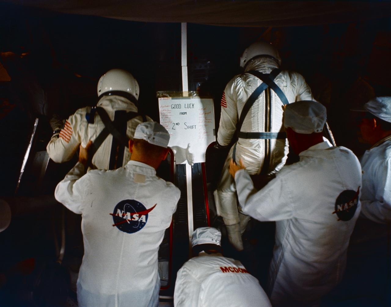 S65-59984 (15 Dec. 1965) --- NASA and McDonnell technicians assist the Gemini-6 prime crew into the spacecraft in the white room atop Pad 19 during the Gemini-6 prelaunch countdown at Cape Kennedy, Florida. Astronaut Walter M. Schirra Jr., command pilot, is on the left; and astronaut Thomas P. Stafford, pilot, is on the right. Liftoff was at 8:37 a.m. (EST) on Dec. 15, 1965. Photo credit: NASA or National Aeronautics and Space Administration