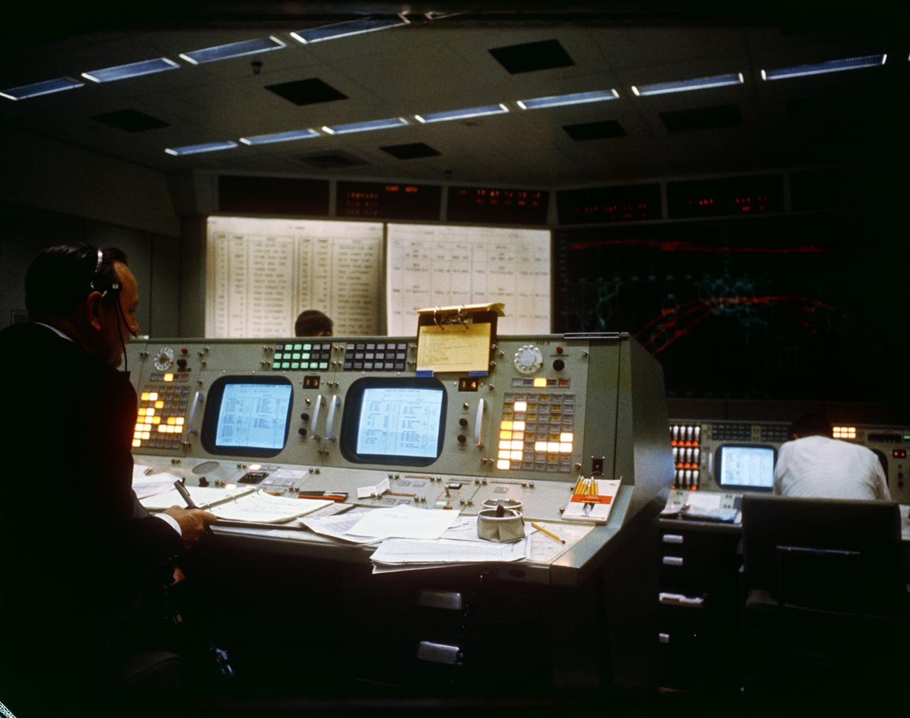 S65-60039 (7 Dec. 1965) --- Christopher C. Kraft Jr. (left), assistant director for Flight Operations, monitors his console in the Mission Control Center during the Gemini-7 spaceflight. Photo credit: NASA