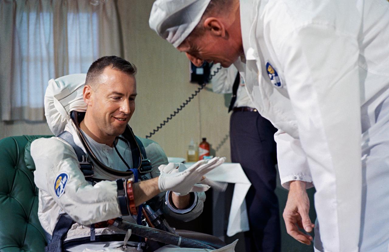 S65-61756 (4 Dec. 1965) --- Astronaut James A. Lovell Jr. (left), Gemini-7 prime crew pilot, talks with NASA spacesuit technician Clyde Teague during suiting up procedures at Launch Complex 16, Kennedy Space Center. Lovell wears the new light-weight spacesuit planned for use during the Gemini-7 mission. Photo credit: NASA