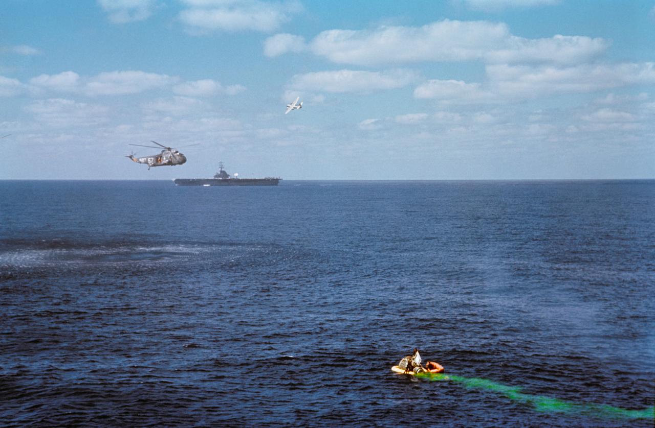 S65-61824 (16 Dec. 1965) --- A helicopter hovers over the Gemini-6 spacecraft after it splashed down 12 miles from the aircraft carrier USS Wasp in the western Atlantic recovery area at 10:29 a.m. Dec. 16, 1965. Photo credit: NASA or National Aeronautics and Space Administration