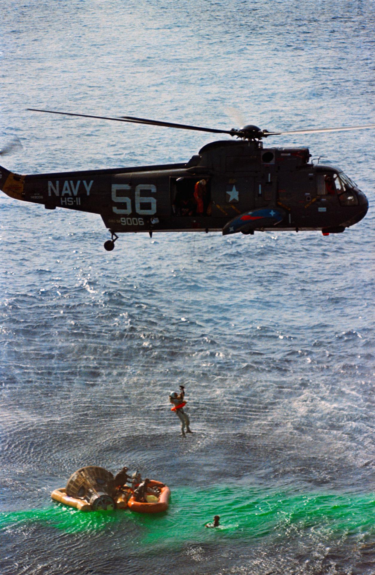 Jim Lovell is hoisted into a helicopter after splashdown of the Gemini VII mission in the Pacific Ocean