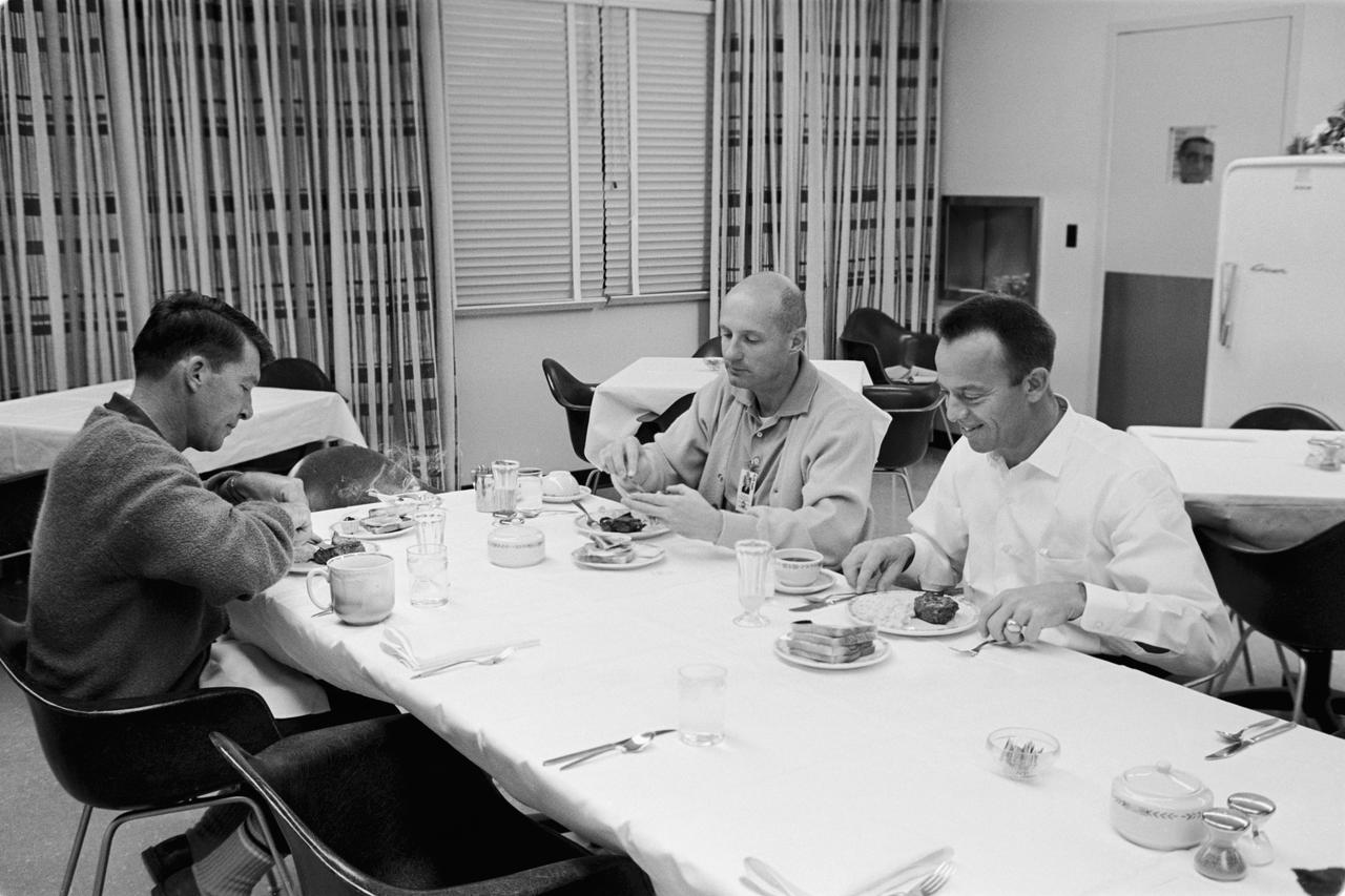 S65-61880 (15 Dec. 1965) --- Astronauts Walter M. Schirra Jr. (left), command pilot; and Thomas P. Stafford (center), pilot, enjoy a breakfast of steak and eggs in the Manned Spacecraft Operations Building, Merritt Island, during the Gemini-6 prelaunch countdown. Seated at right is astronaut Alan B. Shepard Jr., chief, Astronaut Office, Manned Spacecraft Center, Houston, Texas. Gemini-6 was successfully launched from Pad 19 at 8:37 a.m. (EST), Dec. 15, 1965. Photo credit: NASA or National Aeronautics and Space Administration