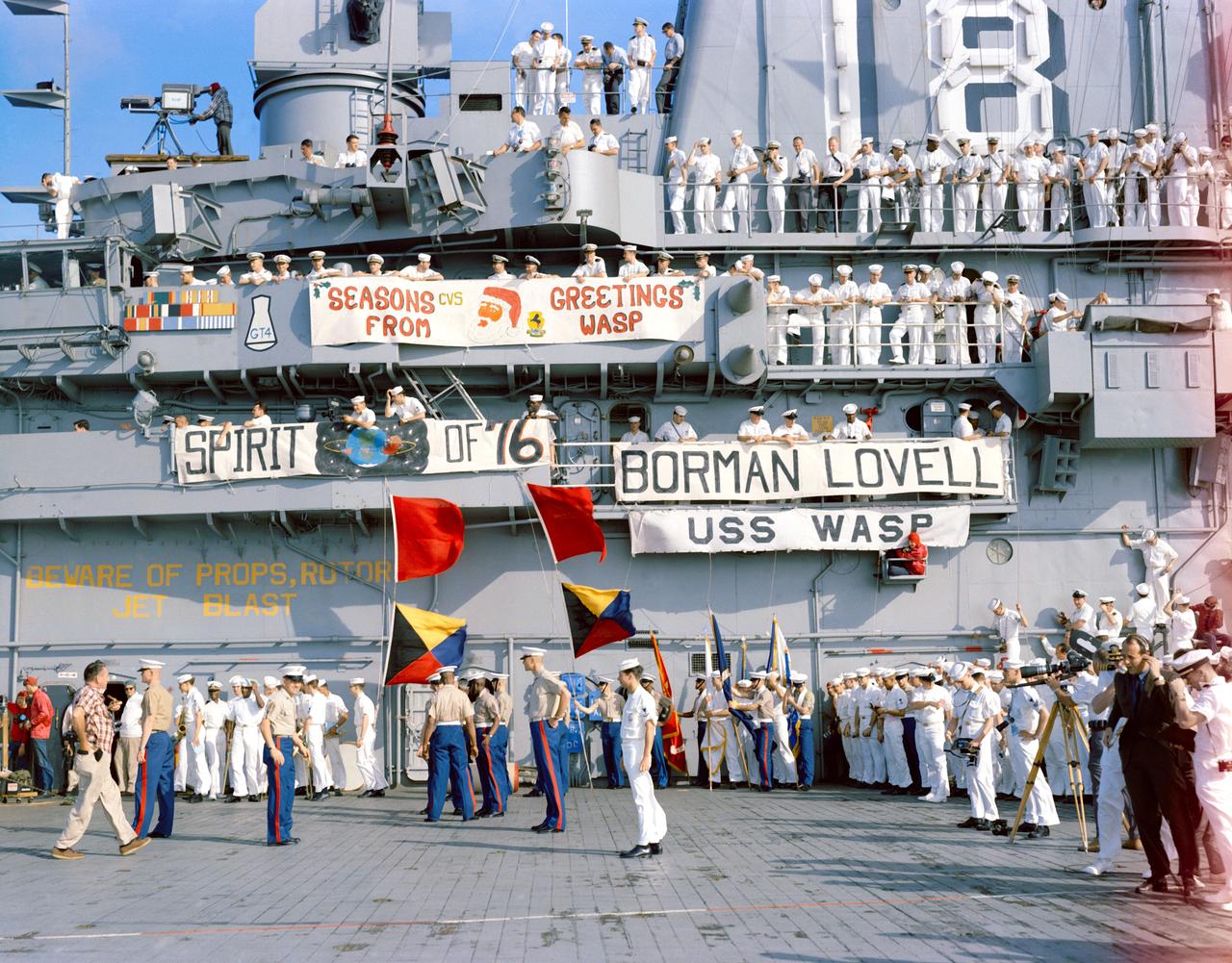 S65-63644 (18 Dec. 1965) --- Crewmen of the aircraft carrier USS Wasp gather on deck to watch the recovery of the National Aeronautics and Space Administration's Gemini-7 spacecraft and astronauts. Gemini-7, with astronauts Frank Borman, command pilot, and James A. Lovell Jr., pilot, splashed down in the western Atlantic at 9:05 a.m. (EST), Dec. 18, 1965, to conclude a record-breaking 14-day mission in space. Photo credit: NASA