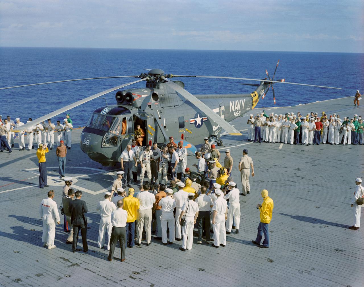 S65-63646 (18 Dec. 1965) --- The crew of the Gemini-7 spaceflight, astronauts Frank Borman, command pilot, and James A. Lovell Jr., pilot, arrive aboard the aircraft carrier USS Wasp. The astronauts were picked up from the ocean, following successful splashdown, by recovery helicopter and flown to the carrier to begin postflight medical and technical debriefings. Photo credit: NASA