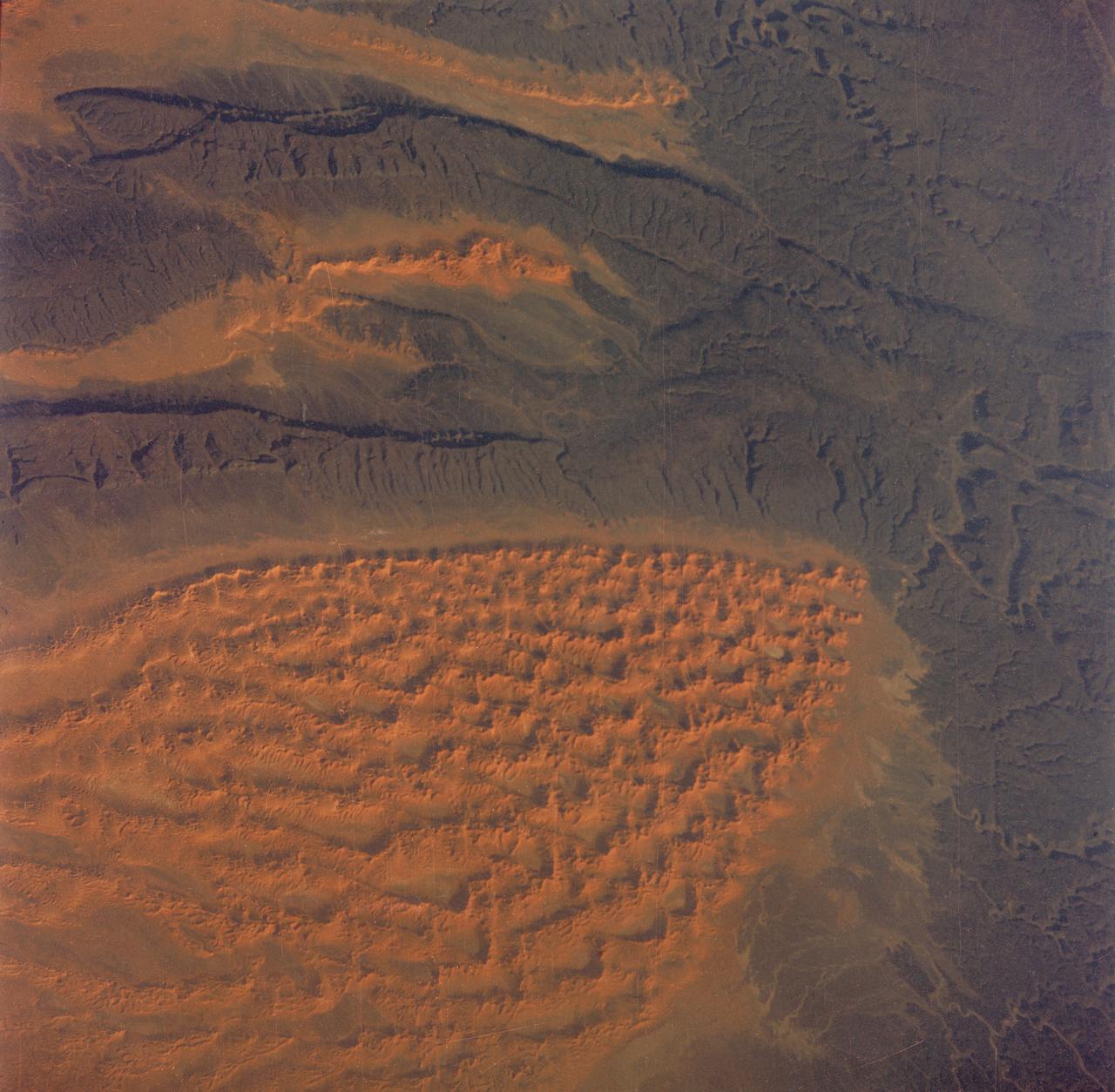 S65-63829 (5 Dec. 1965) --- Algeria, south of the Fort Flatters area, as seen from the National Aeronautics and Space Administration?s Gemini-7 spacecraft during its 13th revolution of Earth. The orange color area is the Tifermine Sand Dunes that reach a height of 1,000 feet. The photograph was taken with a modified 70mm Hasselblad camera, with Eastman Kodak, Ektachrome MS (S.O. 217) color film. Photo credit: NASA