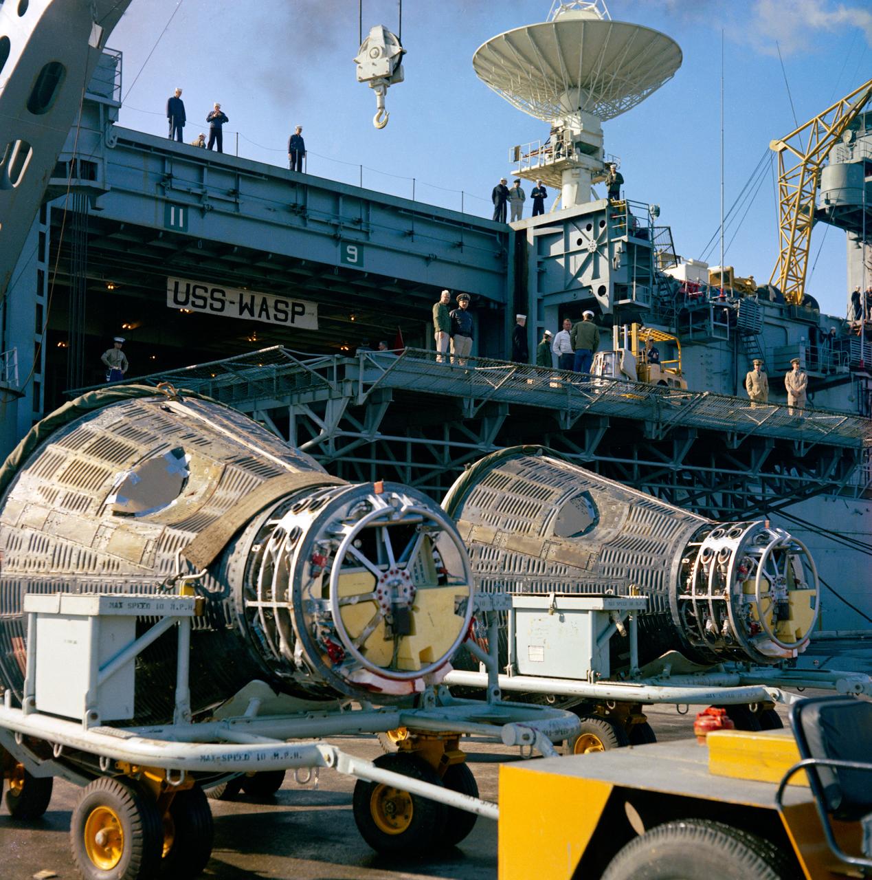 S65-65948 (20 Dec. 1965) --- Gemini-7 (left) and Gemini-6 spacecraft meet up once again, this time at Mayport Naval Station near Jacksonville (Fla.) after unloading Dec. 20, 1965, from the carrier USS Wasp. The two spacecraft accomplished a rendezvous and station keeping exercise in space on Dec. 15. Photo credit: NASA