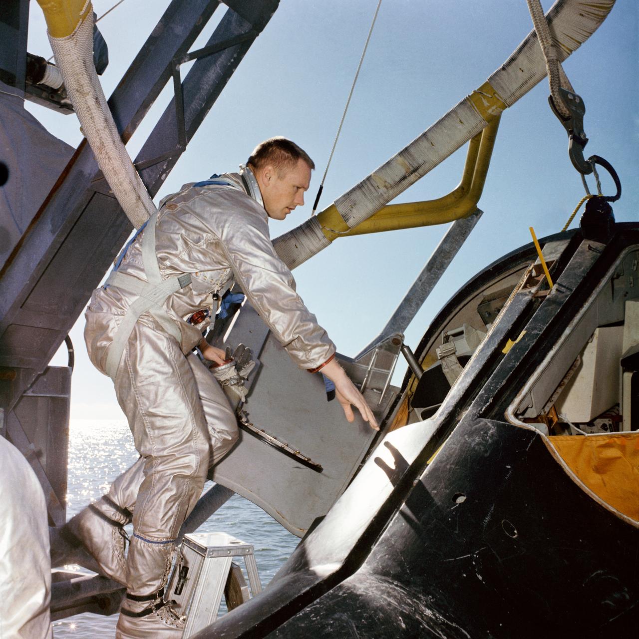 S66-17153 (15 Jan. 1966) --- Astronaut Neil A. Armstrong. Gemini-8 command pilot, climbs into a boilerplate model of the Gemini spacecraft during water egress training on the Gulf of Mexico. Photo credit: NASA
