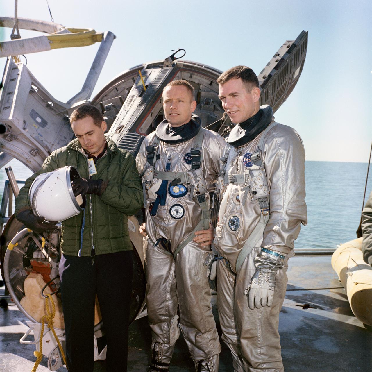 S66-17253 (15 Jan. 1966) --- Astronauts Neil A. Armstrong (center), command pilot, and David R. Scott (right), pilot of the Gemini-8 prime crew, are suited up for water egress training aboard the NASA Motor Vessel Retriever in the Gulf of Mexico. At left is Dr. Kenneth N. Beers, M.D., Flight Medicine Branch, Center Medical Office. Photo credit: NASA