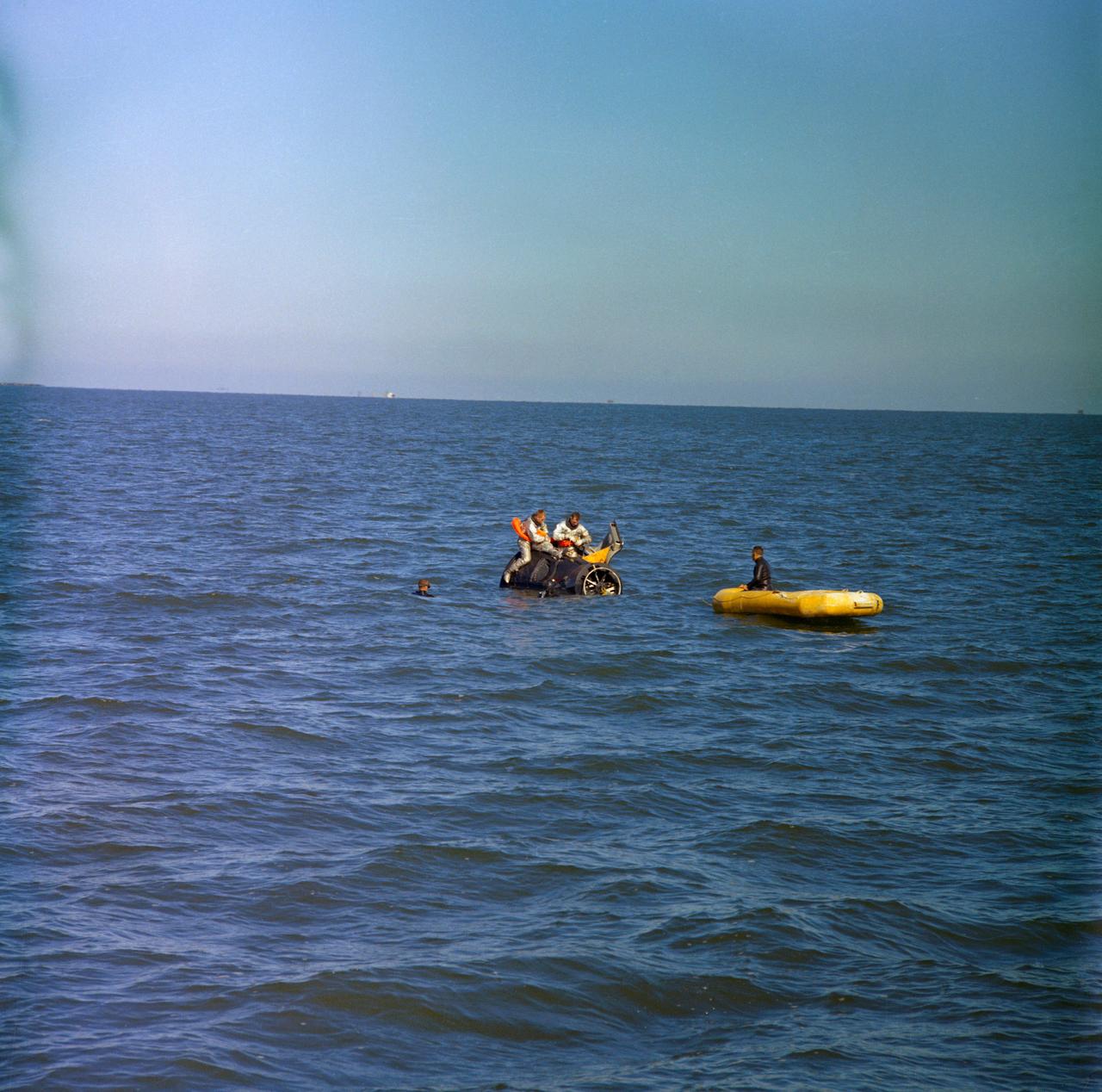 S66-17288 (15 Jan. 1966) --- Astronauts Neil A. Armstrong (on left), command pilot, and David R. Scott, pilot of the Gemini-8 prime crew, use a boilerplate model of a Gemini spacecraft during water egress training in the Gulf of Mexico. Three Manned Spacecraft Center swimmers assist in the training exercise. Photo credit: NASA