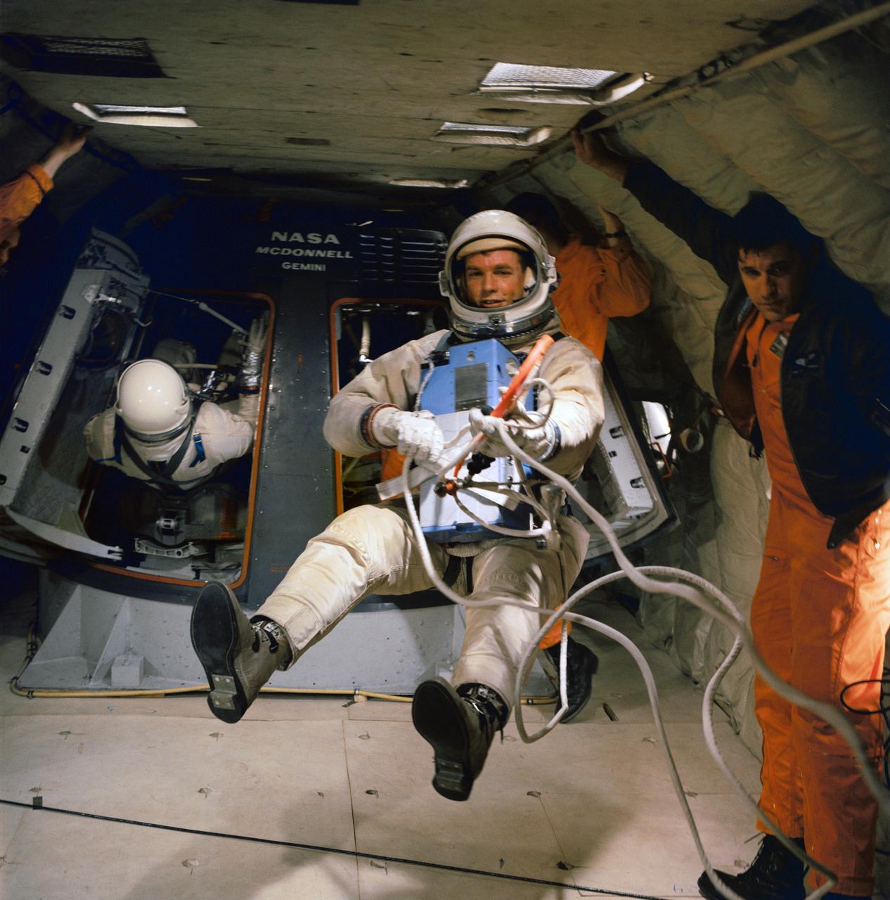 S66-21411 (18 Feb. 1966) --- Astronaut David R. Scott, in full spacesuit, holds maneuvering unit while suspended in a weightless state during extravehicular activity (EVA) training in a C-135 Air Force plane. Photo credit: NASA