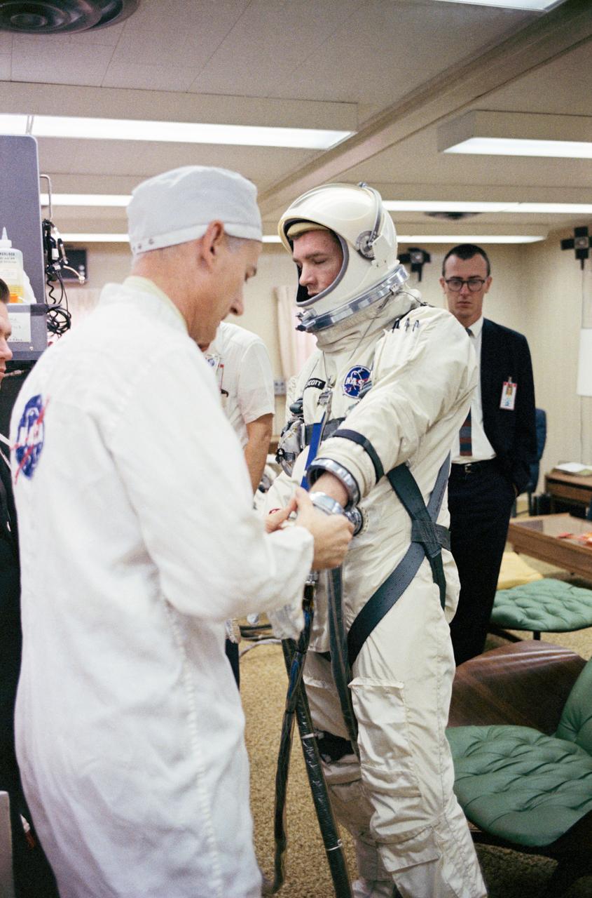S66-24405 (16 March 1966) --- Astronaut David R. Scott, pilot of the Gemini-8 spaceflight, in the Launch Complex 16 trailer during suiting up operations for the Gemini-8 mission. NASA suit technician Joe Schmitt helps the astronaut put on his gloves. Photo credit: NASA