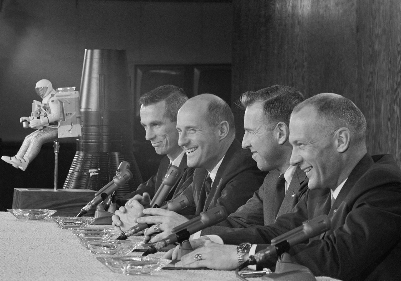 S66-24580 (23 April 1966) --- The two crews of the Gemini-9 spaceflight appear before a gathering of news media representatives during a press conference in the MSC News Center, Building 6. Left to right, are astronauts Eugene A. Cernan, prime crew pilot; Thomas P. Stafford, prime crew command pilot; James A. Lovell Jr., backup crew command pilot; and Edwin E. Aldrin Jr., backup crew pilot. A Gemini spacecraft model and a model of an astronaut wearing an Astronaut Maneuvering Unit (in background) were used to explain the Gemini-9 mission. Photo credit: NASA
