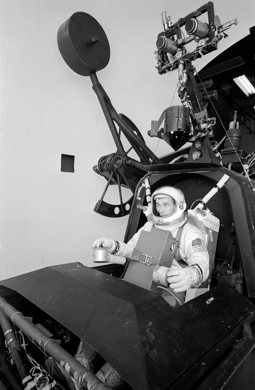 S66-27990 (March 1966) --- Astronaut Eugene A. Cernan, pilot for the Gemini-9 spaceflight, works out procedures for his historic space excursion in a unique manned Aerospace Flight Simulator at LTV Corp. at Dallas, Texas. The LTV simulator is used frequently by NASA astronauts for a variety of space programs maneuvers to provide many of the sensations and visual scenes of actual spaceflight. Controlled through a complex of computers, the device makes it possible for the astronauts to work out procedures, solve problems and simulate missions in real time with great accuracy. The astronaut rides in a spacecraft-like gondola which moves in roll, pitch and yaw in response to his controls and accurate computer inputs. The simulator's usual spacecraft displays and canopy have been removed and AMU backpack complete with control electronics installed. The astronaut makes his simulated flight in an inflated pressure suit and with the NASA-developed Extravehicular Life Support system chest pack which will be used in the Gemini flight. Photo credit: NASA
