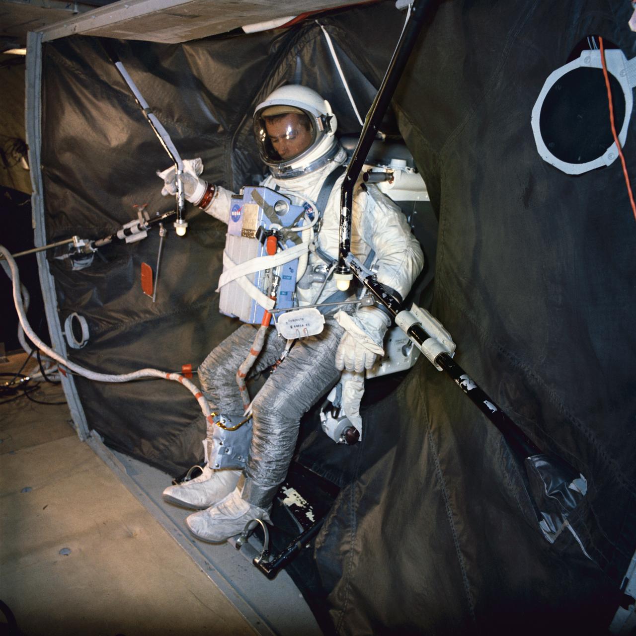 S66-31665 (3 May 1966) --- Astronaut Eugene A. Cernan, pilot of the Gemini-9 spaceflight, participates in extravehicular training under zero-gravity conditions aboard a KC-135 aircraft. Here, he is donning the Astronaut Maneuvering Unit (AMU) backpack after egressing a Gemini mock-up. The AMU backpack is mounted in the adapter equipment section of the mock-up. Cernan wears an extravehicular activity (EVA) life support system chest pack. Cernan will use the AMU during his scheduled EVA on the Gemini-9 mission. The KC-135 flew a parabolic curve to create the weightlessness condition for training purposes. Photo credit: NASA