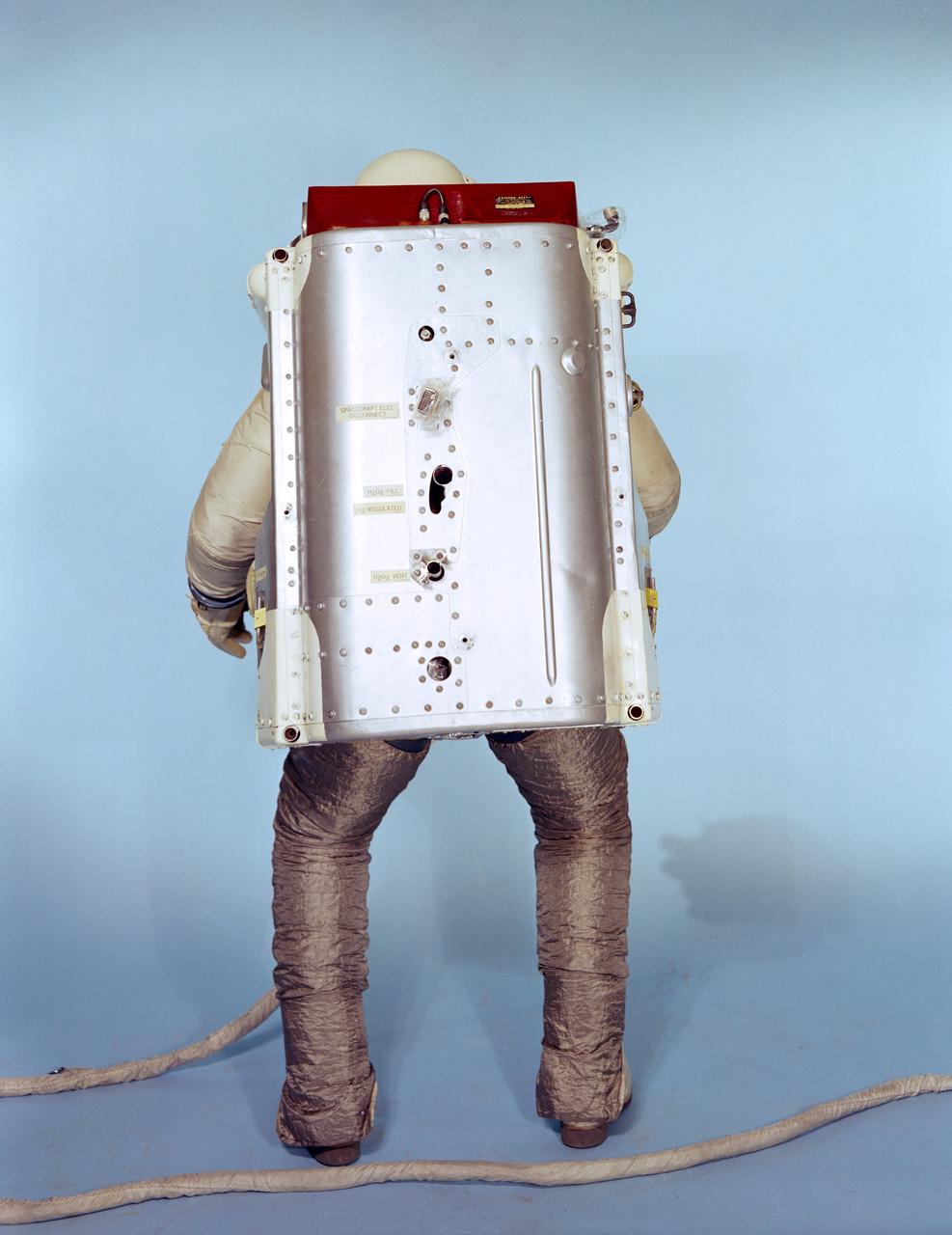 S66-33163 (May 1966) --- Rear view of the Astronaut Maneuvering Unit (AMU), worn by test subject Fred Spross, Crew Systems Division. The Gemini spacesuit, backpack and chest pack comprise the AMU, a system which is essentially a miniature manned spacecraft. The spacesuit legs are covered with Chromel R, which is a cloth woven from stainless steel fibers, used to protect the astronaut and suit from the hot exhaust thrust of the AMU backpack. Astronaut Eugene A. Cernan will wear the AMU during his Gemin-9A extravehicular activity (EVA). Photo credit: NASA