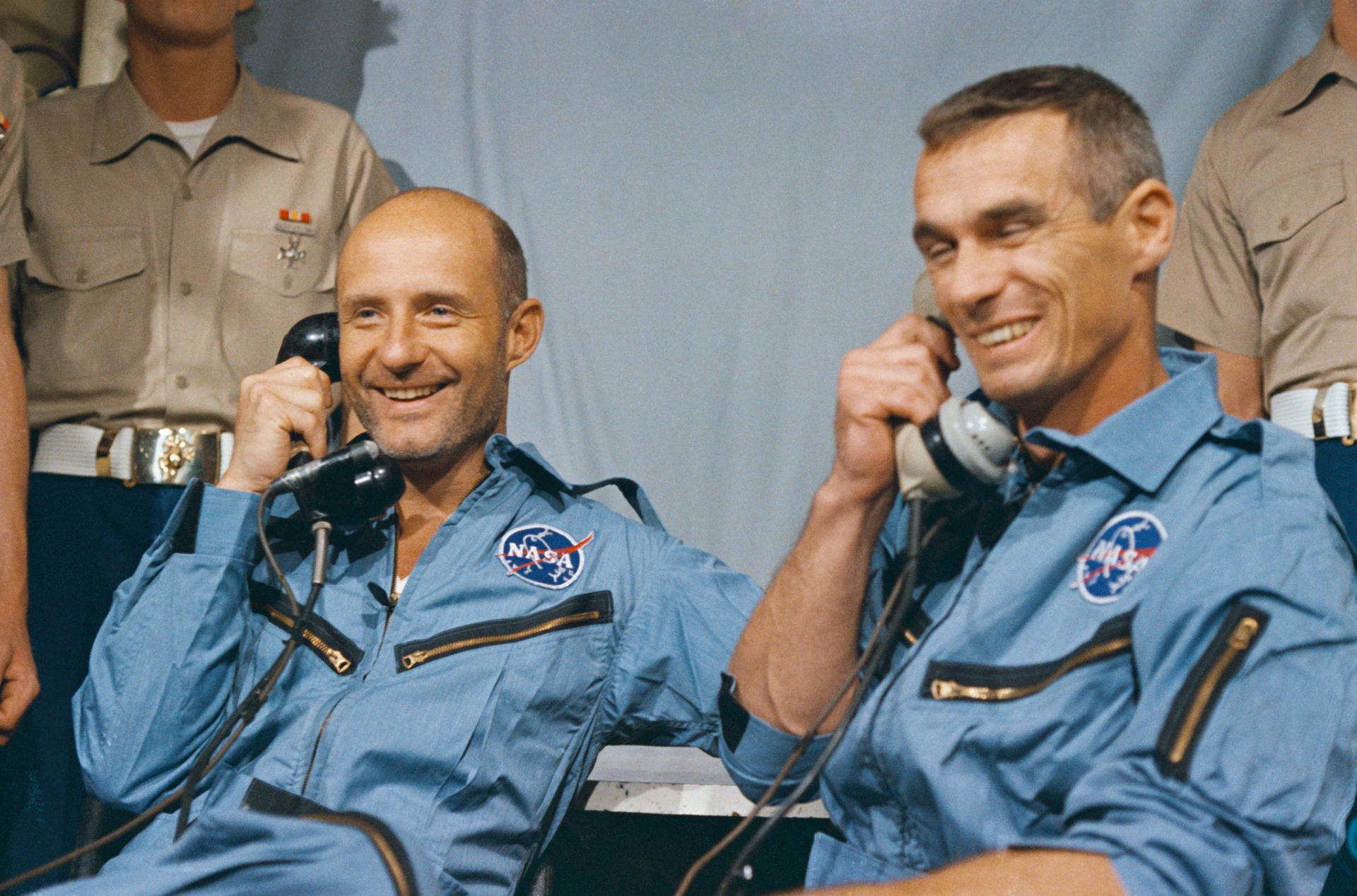 Astronauts Tom Stafford and Gene Cernan smile as they talk on the phone with President Johnson after their Gemini-9A spaceflight