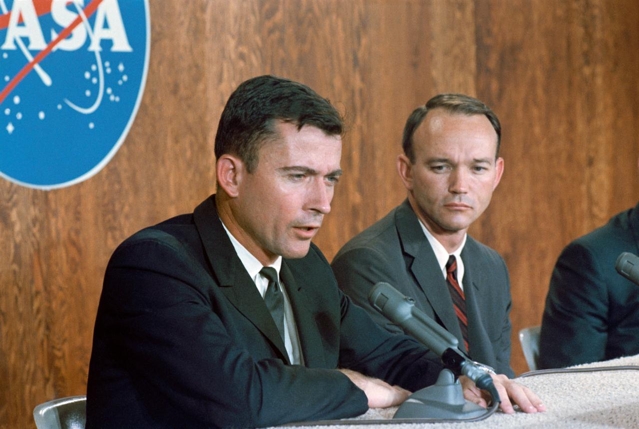 S66-39769 (2 July 1966) --- Astronauts John W. Young (left), command pilot, and Michael Collins, pilot, the prime crew of the Gemini-10 spaceflight, discuss their forth-coming mission before a gathering of news media representatives at a press conference in the Manned Spacecraft Center News Center, Building 6, Houston, Texas. Photo credit: NASA