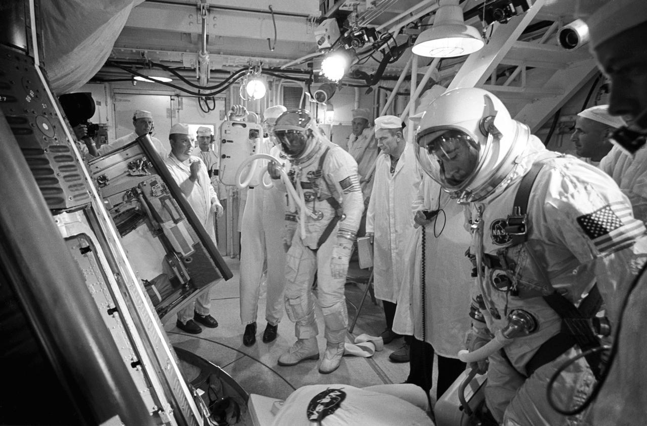 S66-42737 (18 July 1966) --- In the White Room atop the Gemini launch vehicle, astronauts Michael Collins (left), pilot, and John W. Young (right), command pilot, prepare to enter the Gemini-10 spacecraft. Engineers and technicians stand by to assist in the insertion. Photo credit: NASA