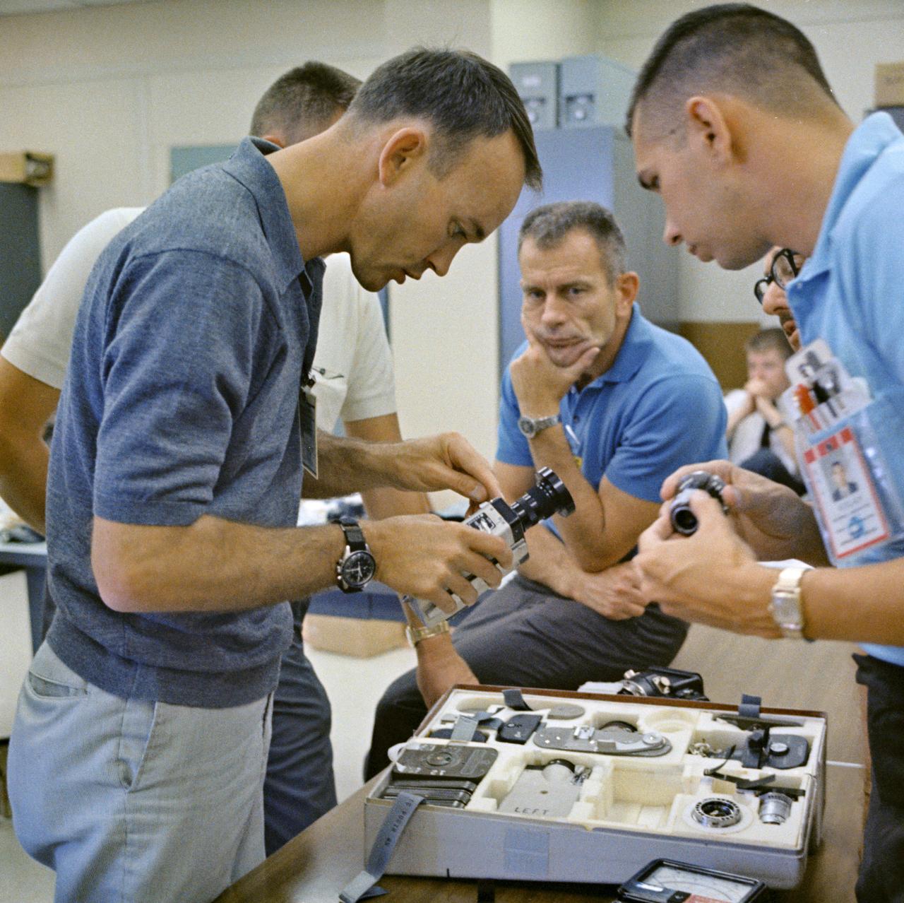 S66-42763 (18 July 1966) --- Astronaut Michael Collins (left), Gemini-10 prime crew pilot, inspects a camera during prelaunch activity at Cape Kennedy, Florida. In center background is Dr. Donald K. Slayton, Manned Spacecraft Center (MSC) Director of Flight Crew Operations. Photo credit: NASA