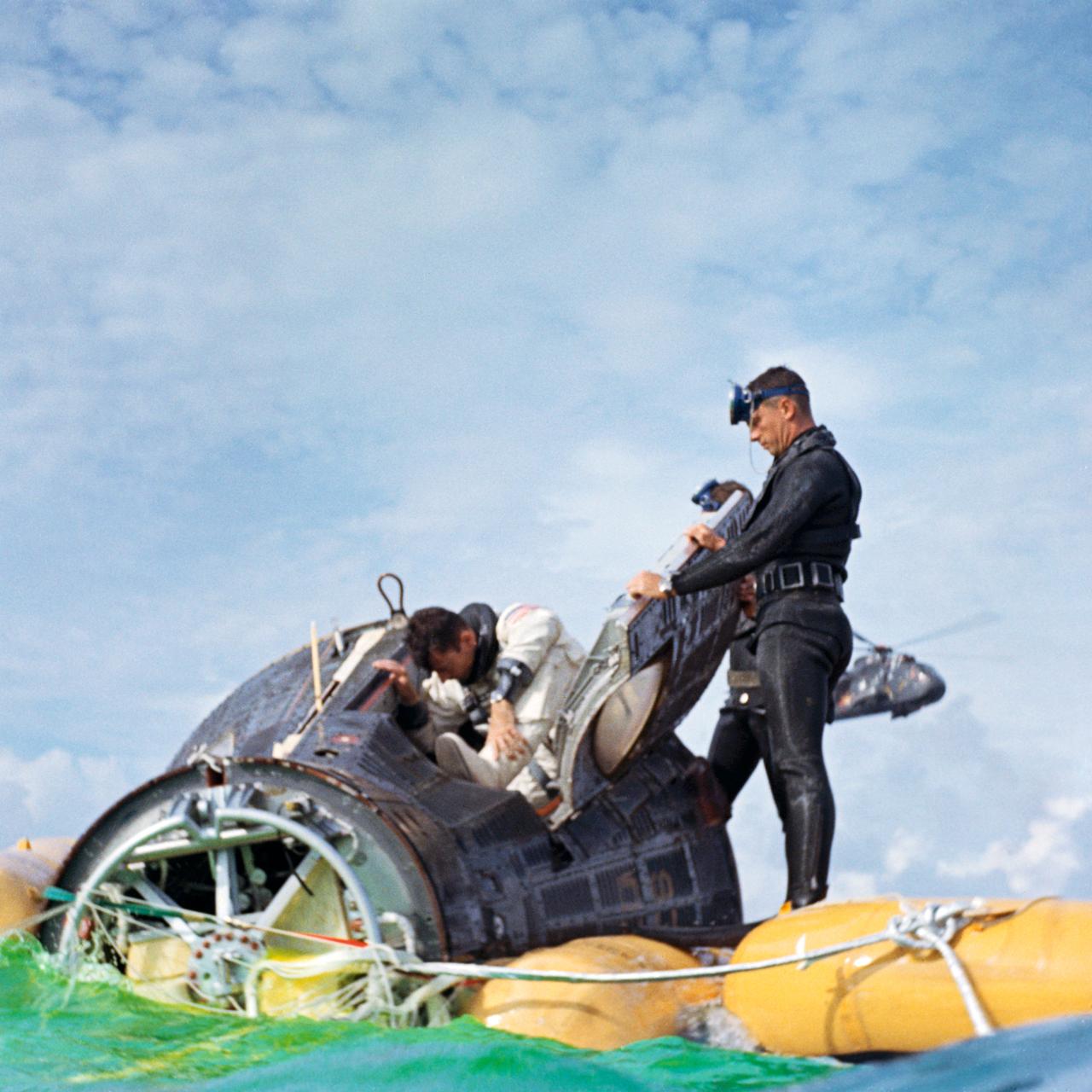 S66-42772 (21 July 1966) --- A U.S. Navy frogman assist the Gemini-10 crew following splashdown at 4:07 p.m. (EST), July 21, 1966, about four miles from the recovery ship, USS Guadalcanal. Astronaut John W. Young (climbing from spacecraft), command pilot, and Michael Collins (in spacecraft), pilot, were later hoisted from the water by a recovery helicopter and flown to the Guadalcanal. Photo credit: NASA