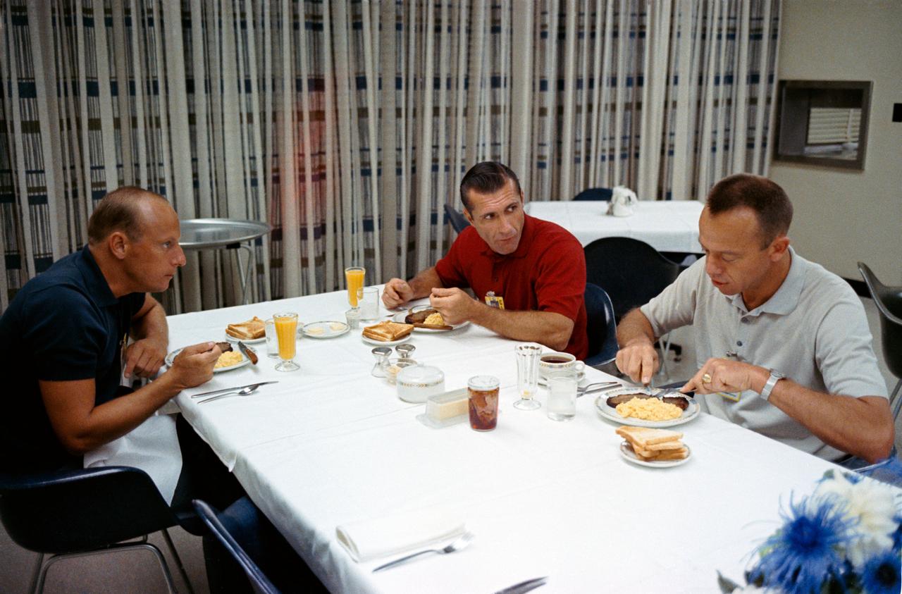 S66-50723 (12 Sept. 1966) --- The Gemini-11 prime crew enjoys a breakfast of steak and eggs with astronaut Alan B. Shepard Jr. (right), Chief, MSC Astronaut Office, on the morning of the scheduled Gemini-11 launch. On left is astronaut Charles Conrad Jr., command pilot. Astronaut Richard F. Gordon Jr. (center) is the pilot. Photo credit: NASA