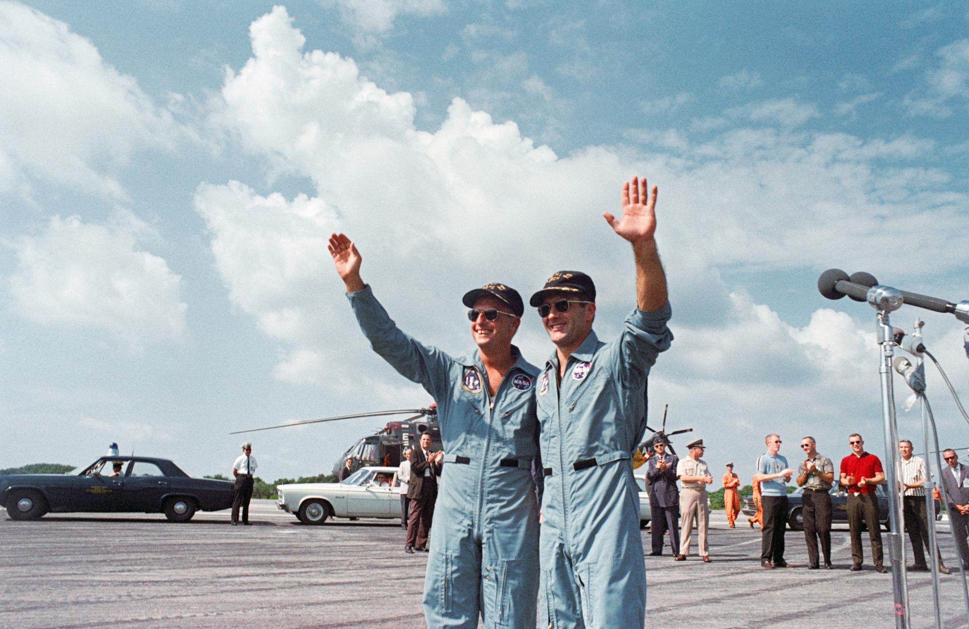 Pete Conrad and Dick Gordon wave to a crowd