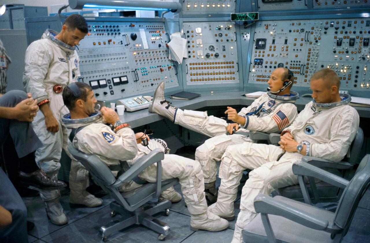S66-50769 (8 Sept. 1966) --- Gemini-11 prime and backup crews are pictured at the Gemini Mission Simulator at Cape Kennedy, Florida. Left to right are astronauts William A. Anders, backup crew pilot; Richard F. Gordon Jr., prime crew pilot; Charles Conrad Jr. (foot on desk), prime crew command pilot; and Neil A. Armstrong, backup crew command pilot. Photo credit: NASA