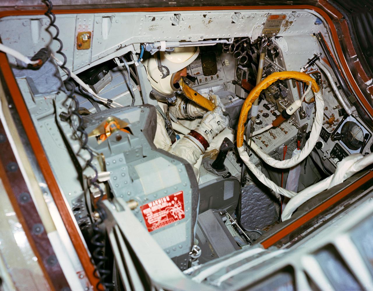 S66-51054 (15 Aug. 1966) --- Astronaut James A. Lovell Jr., prime crew command pilot of the Gemini-12 space mission, simulates using space food packet while seated in the Gemini-12 spacecraft in the 30-feet Altitude Chamber at McDonnell Aircraft Corporation, St. Louis, Missouri. Photo credit: NASA