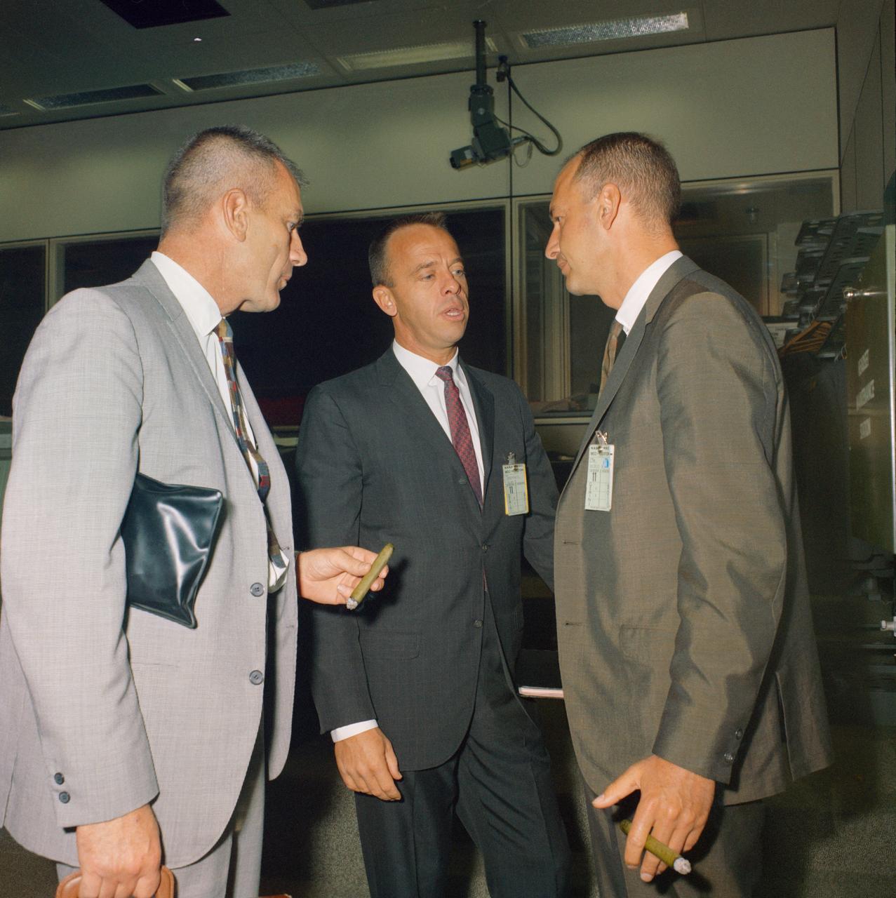 S66-52754 (12 Sept. 1966) --- Three key Manned Spacecraft Center (MSC) officials hold discussion in the Mission Control room during Gemini-11 activity. Left to right, are Donald K. Slayton, MSC Director of Flight Crew Operations; astronaut Alan B. Shepard Jr., Chief, MSC Astronaut Office; and George M. Low, MSC Deputy Director. Photo credit: NASA