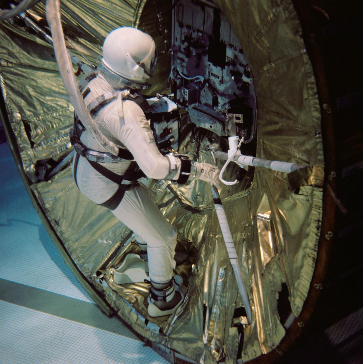 S66-54939 (29 Oct. 1966) --- Astronaut Edwin E. Aldrin Jr., pilot for the Gemini-12 spaceflight, practices work tasks during underwater zero-gravity training. He is placing his feet into a special foot plate in an adapter section of the spacecraft. The foot plate will help secure him to the spacecraft during extravehicular activity (EVA). The underwater environment closely simulates the zero-gravity condition found in space. Photo credit: NASA