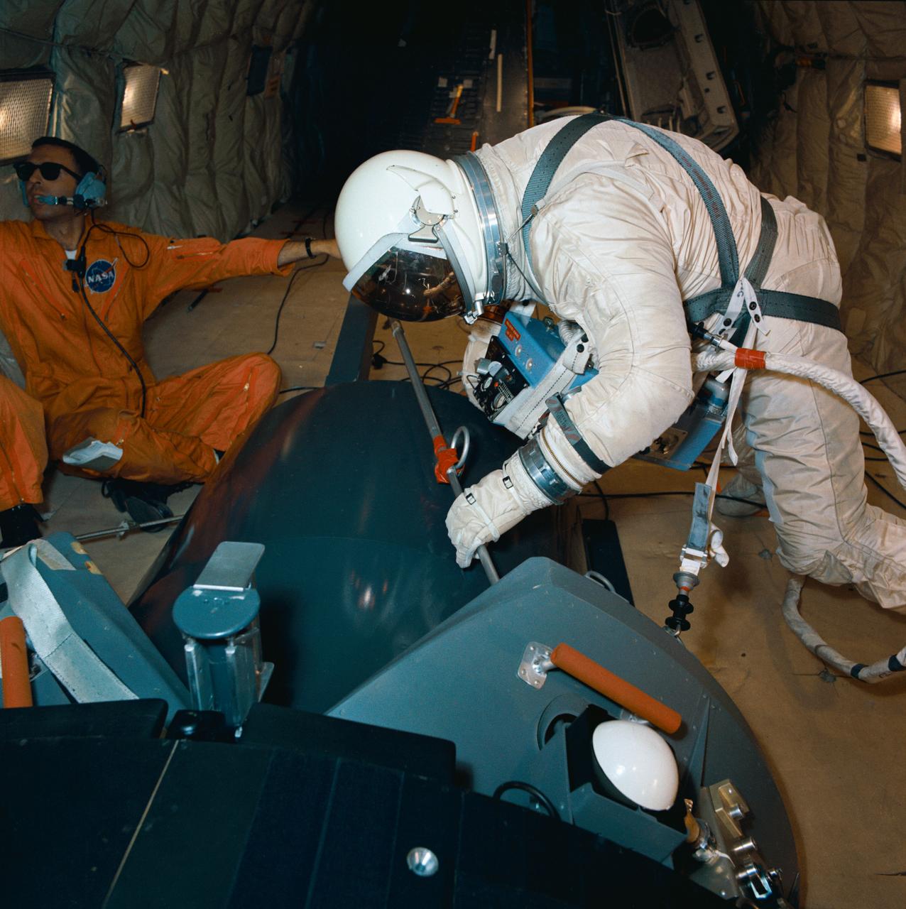 S66-57387 (13 Oct. 1966) --- Astronaut Edwin E. Aldrin Jr., pilot for the Gemini-12 spaceflight, practices work tasks during zero-gravity training. He is secured to a mock-up of the Agena Target Docking Vehicle by special tethers. The training took place onboard an Air Force KC-135 jet aircraft. Photo credit: NASA