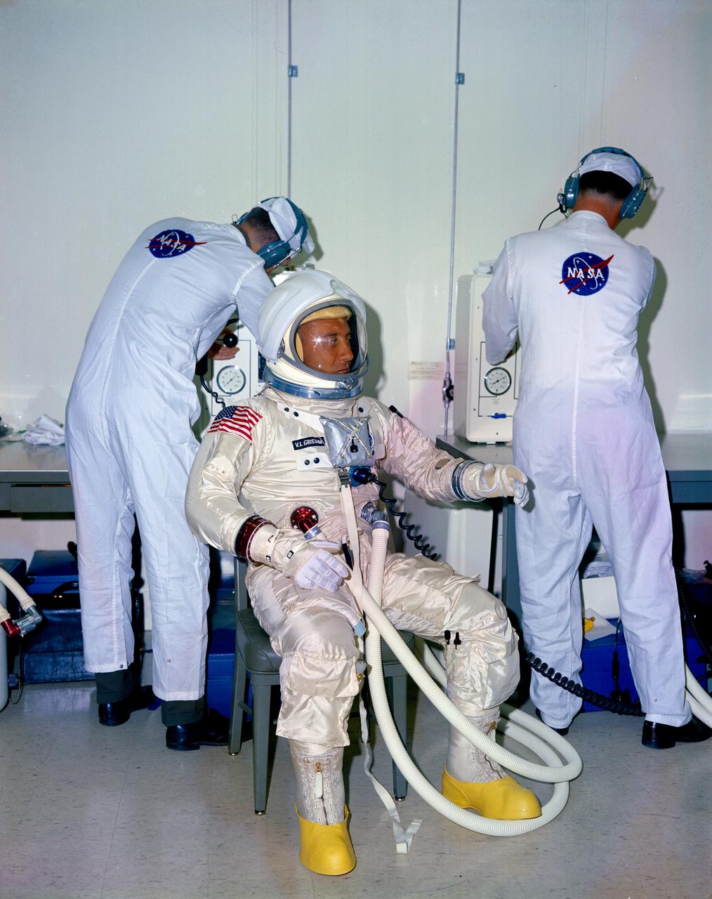 S66-58023 (1966) --- NASA suit technicians assist astronaut Virgil I. Grissom during suiting operations prior to tests at the Kennedy Space Center.