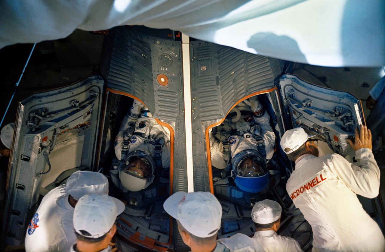 S66-59971 (11 Nov. 1966) --- Technicians prepare to close the hatches of the Gemini-12 spacecraft in the white room atop Pad 19 after insertion of astronaut James A. Lovell Jr. (left), command pilot, and Edwin E. Aldrin Jr., pilot. Liftoff was at 3:46 p.m. (EST), Nov. 11, 1966. Photo credit: NASA